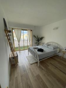 una camera con letto e pavimento in legno di Comfortable apartment with parking - Antibes Riviera a Antibes