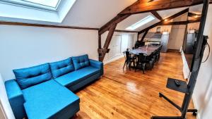 a living room with a blue couch and a table at Moulin des ducs grand format by Vindihouses - piscine chaffée - escalade - billard - fitness - etc in Épinac-les-Mines