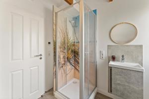 a bathroom with a shower and a sink and a mirror at Huus Frieda in Krummhörn +26 photos