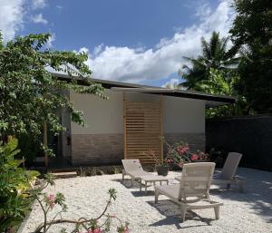 a group of chairs sitting in front of a house at Pare LODGE TAHITI in Pirae