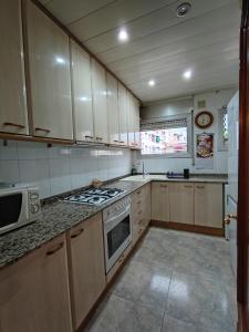 a kitchen with white cabinets and a stove top oven at LG DownTown Sabadell Apartment in Sabadell