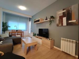 a living room with a couch and a flat screen tv at LG DownTown Sabadell Apartment in Sabadell