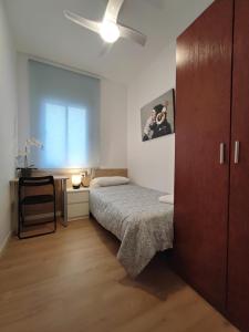 a small bedroom with a bed and a desk at LG DownTown Sabadell Apartment in Sabadell