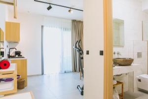 萨索斯Essentia Vita Comfy Suites的带水槽和镜子的白色浴室