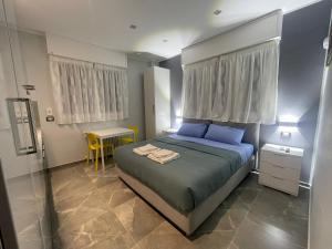 een slaapkamer met een bed met blauwe kussens en een tafel bij Residenza Gioiello - Comfort & Suites a Milano in Milaan