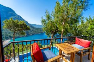 a balcony with a table and chairs and a view of a river at Manzara Bungalov in Fethiye
