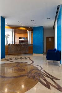 a lobby with blue walls and a drawing on the floor at Hotel Pombalense in Pombal