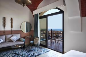 a living room with a couch and a balcony at The Cove Rotana Resort - Ras Al Khaimah in Ras al Khaimah