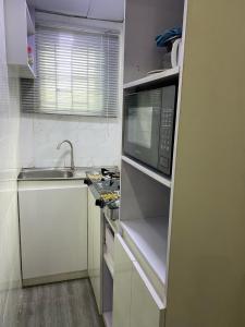 a small kitchen with a microwave and a sink at HOUSE 27 HABITAT in Lagos