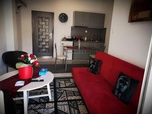 a living room with a red couch and a table at Centrally Apartments in Xanthi