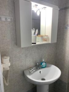 a bathroom with a white sink and a mirror at Fabrika Apartment B2 in Vári