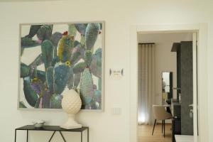 ein Wohnzimmer mit einem Gemälde eines Kaktus in der Unterkunft Enea Suite in Trapani