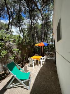 a patio with a table and chairs and an umbrella at I Villini in Castellaneta Marina 