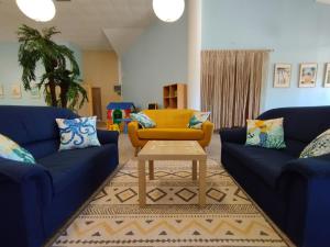 uma sala de estar com dois sofás azuis e uma mesa em CASA DA DUNA - Salir do Porto em Salir do Porto