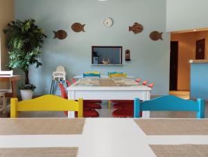 a dining room with a table with colorful chairs at CASA DA DUNA - Salir do Porto in Salir de Porto
