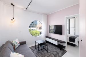 uma sala de estar com um sofá e uma cama em The Flamingo Private Apartments by Perch Stays na Cidade do Cabo