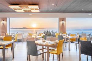 a restaurant with tables and chairs and a view of the ocean at Melia Alicante in Alicante