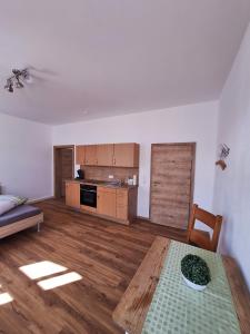 a living room with a table and a kitchen at Gasthof Adler Ferienwohnung in Ichenhausen
