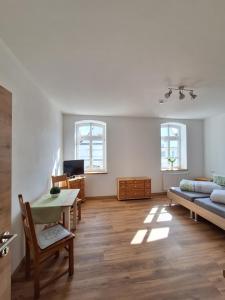 een woonkamer met een tafel en een bank bij Gasthof Adler Ferienwohnung in Ichenhausen