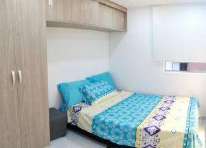 a small bedroom with a bed and a cabinet at Hermoso Apartamento en Neiva in Neiva
