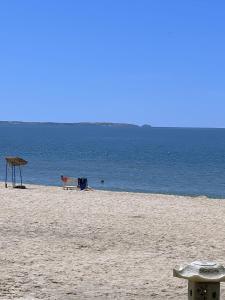 um banco numa praia com o oceano ao fundo em Nhà Nghỉ 86 Hàm Tiến em Phan Thiet