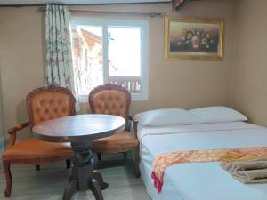 ムック島にあるSeaside homeのベッド2台、テーブル、椅子が備わる客室です。