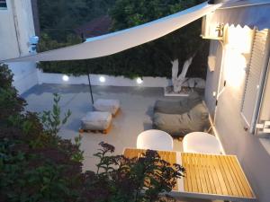 a patio with a couch and a table and chairs at Modern Apartment 10mins from the Beach in Kefallonia