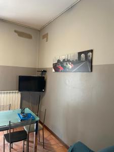 a living room with a table and a car picture on the wall at Grazioso Trilocale Centro/Stazione in Brescia