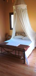 a bedroom with a bed with a mosquito net at Cozy Apollon Villa, Sea View, Next To Galaxidi in Eratini