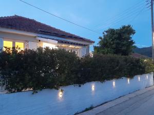 a house with a fence with lights on it at Modern Apartment 10mins from the Beach in Kefallonia