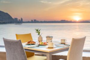 - une table avec un repas sur la plage au coucher du soleil dans l'établissement Melia Alicante, à Alicante