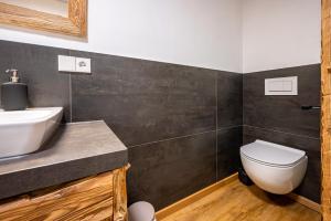 Łazienka z białą toaletą i umywalką w obiekcie Valentin36 Apartment Raschötz w mieście Funes