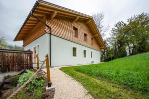 a small house with a wooden roof and a pathway at Valentin36 Apartment Raschötz in Funes