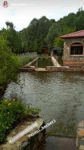 une masse d'eau avec un bâtiment au milieu dans l'établissement Gioia Resort, à Voskopojë