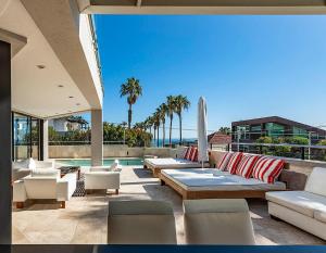 a patio with couches and chairs and a pool at Villa Legacy in Cape Town
