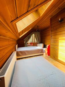 sypialnia z łóżkiem w drewnianym pokoju w obiekcie Šalkoni w mieście Pape