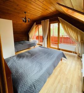 sypialnia z dużym łóżkiem i dużym oknem w obiekcie Šalkoni w mieście Pape