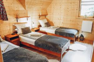 um quarto com duas camas num chalé de madeira em Domki u Jacka - sauna bilard tenis air hockey piłkarzyki bawialnia plac zabaw em Czerwienne