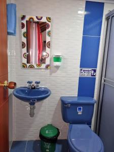 a bathroom with a blue toilet and a sink at Hospedaje Villa Isabel in Aquitania