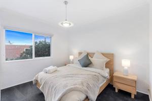 um quarto com uma cama com 2 candeeiros e uma janela em A Home away from home in Geelong em Geelong