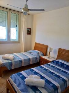 a bedroom with two beds and a window at Attico sul Porto Vecchio - Lampedusa in Lampedusa