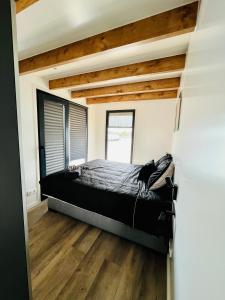 1 dormitorio con 1 cama en una habitación con suelo de madera en Surla Houseboat "De Albatros" in Monnickendam Tender included, en Monnickendam