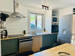 kuchnia ze zlewem i lodówką w obiekcie Chalet domaine forge 6-8pers jacuzzi terrasse plancha proche commerces w mieście La Teste-de-Buch +11 zdjęć