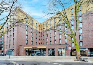 ein großes Backsteingebäude in einer Stadtstraße in der Unterkunft Premier Inn Düsseldorf City Friedrichstadt in Düsseldorf