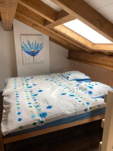 łóżko z niebieskimi kwiatami w pokoju w obiekcie Bienvenue chez les Quadeurs 