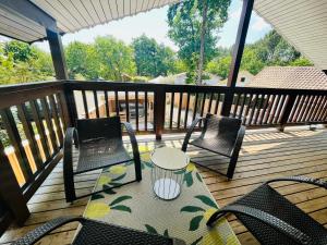 dwa krzesła i stół na drewnianym tarasie w obiekcie Chalet domaine forge 6-8pers jacuzzi terrasse plancha proche commerces w mieście La Teste-de-Buch