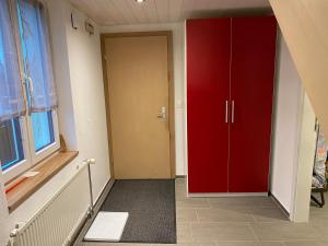 einen Flur mit einer roten Tür und einem Fenster in der Unterkunft Bienvenue chez les Quadeurs 