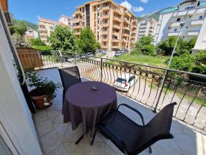 einen Tisch und Stühle auf einem Balkon mit Straßenblick in der Unterkunft Guest House Damjana in Budva