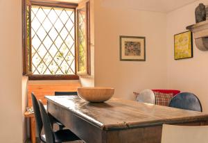 uma sala de jantar com uma mesa de madeira e uma janela em Verzasca Lodge Carlotta em Frasco
