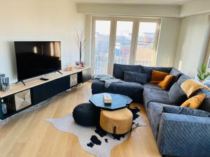 sala de estar con sofá y TV en Le Sable Doux - Gent, en Gante